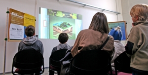 Besucher der Wissenschaftsnacht sehen sich einen Film der GEOmontan GmbH über die geologische Entwicklung Nordsachsens an.